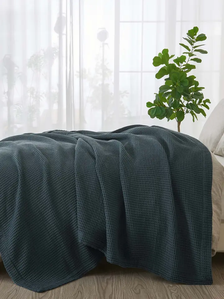 Teal waffle blanket on a bed