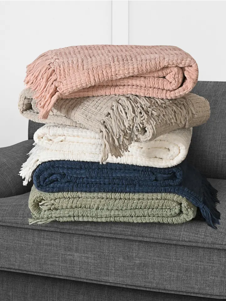 Stack of chenille throws on a sofa