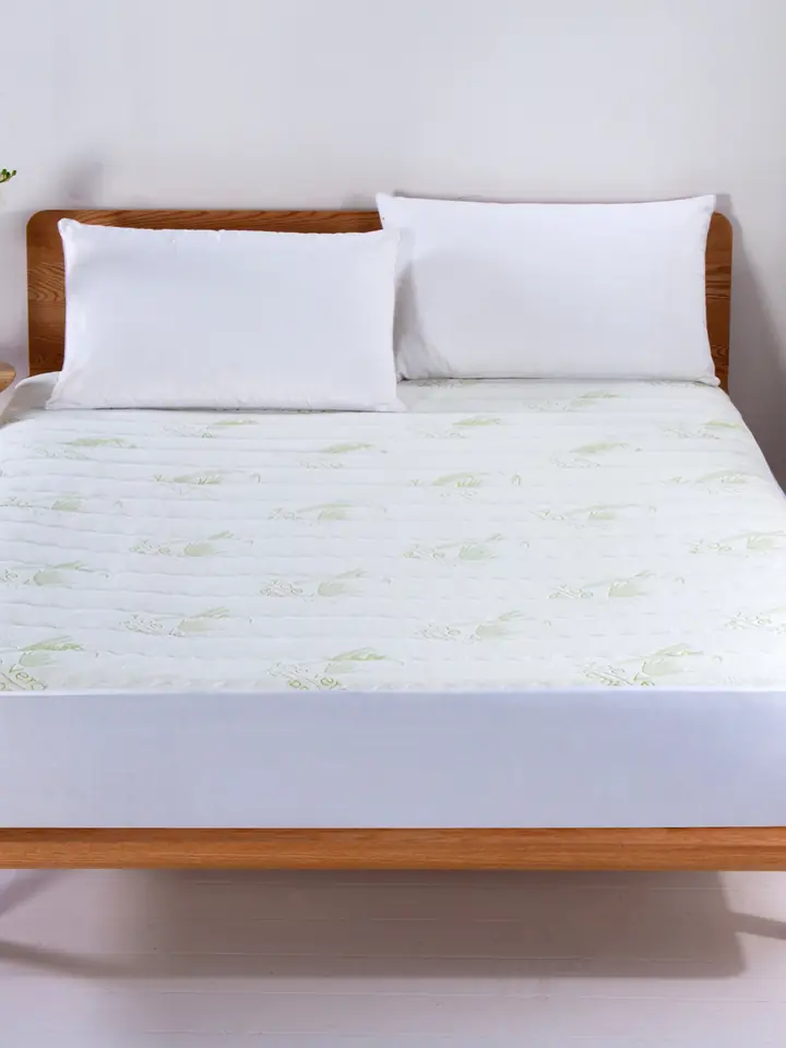 Aloe vera quilted mattress protector on a bed